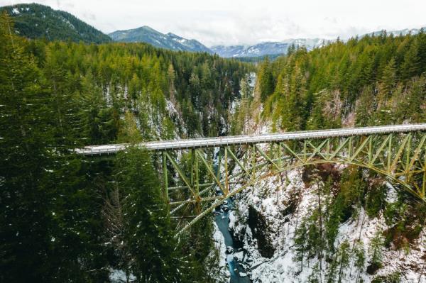 Girl standing at High Steel Bridge, a truss arch bridge above Skokomish River in Washington State, USA