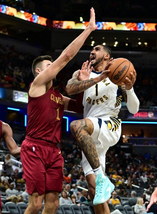 Indiana Pacers forward Obi Toppin, right, looks to shoot in front of Cleveland Cavaliers guard Max Strus.