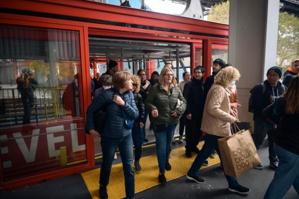 Dozens of people exiting a Roosevelt Island tram car. 