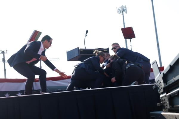 former President Do<em></em>nald Trump is rushed offstage during a rally on July 13, 2024 in Butler, Pennsylvania.