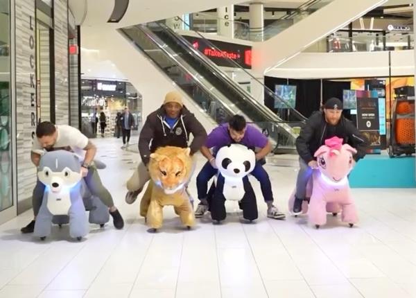 A photo of four UFC fighters racing in the American Dream Mall on the Dream Riders animals.