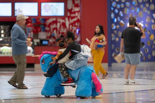 Folks enjoying Dream Riders at the American Dream Mall. In this photo, a mom and her daughter.