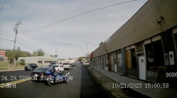 The motorcycle driver seemingly isn't paying attention and has to swerve into another lane to avoid a rear-end collision. 