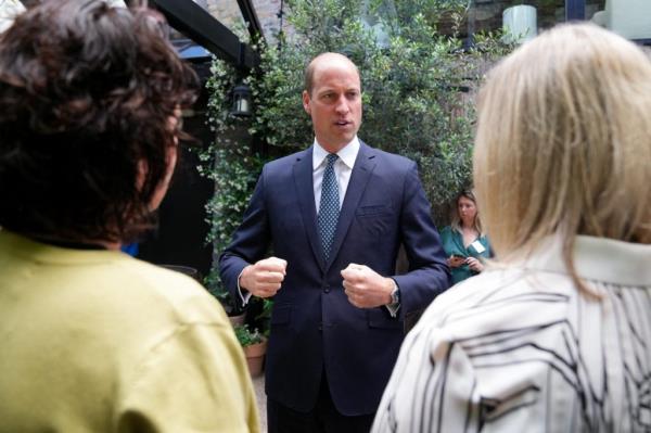 Prince William, Duke of Cambridge, gesturing during a visit to the homelessness initiative Homewards in Lambeth, London, standing in front of a group of people