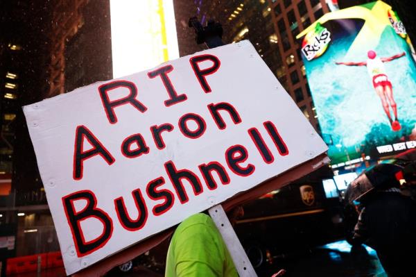 Protester holding AAron Bushnell sign