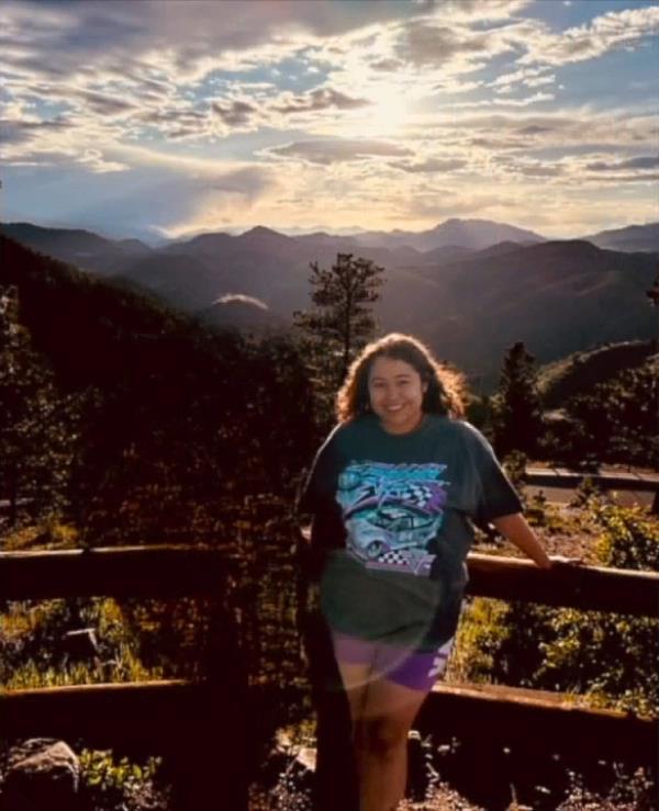 Ruby Garcia stands near nature.