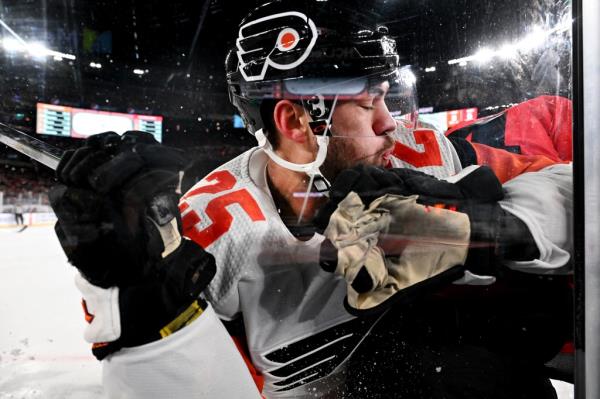 Flyers center Ryan Poehling is checked by Nathan Bastian during the Devils' win.