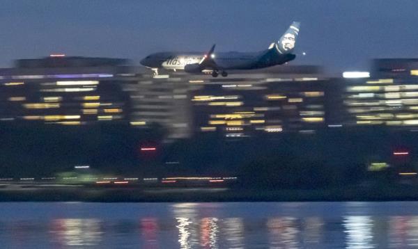 Alaska Airlines Boeing 737-800 aircraft as seen landing at dusk time at Ro<em></em>nald Reagan Washington Natio<em></em>nal Airport DCA in Arlington County, Virginia over the Potomac River 