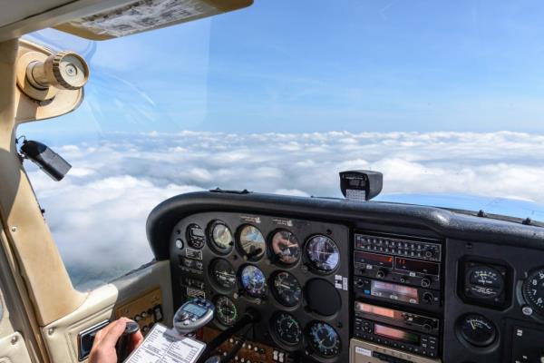 View from a cockpit of a small engine vehicle over an almost closed cloud cover