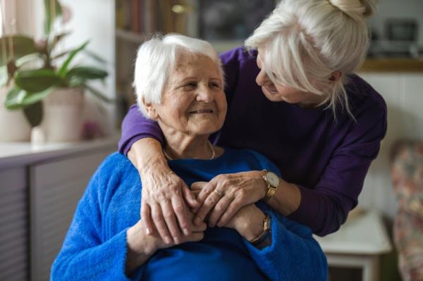 Woman hugging her elderly mother.