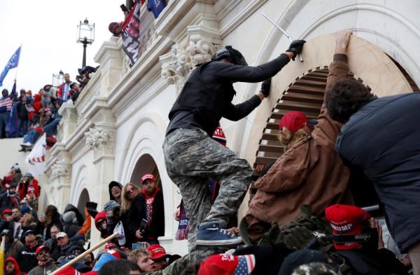 Pro-Trump protesters scale a wall as they storm the U.S. Capitol Building, during clashes with Capitol police at a rally to co<em></em>ntest the certification of the 2020 U.S. presidential election results by the U.S. Congress, in Washington, U.S, January 6, 2021.