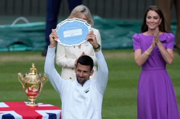 Novak Djokovic of Serbia hold up his runner-up trophy after his defeat by Carlos Alcaraz of Spain in the men's singles finalat the Wimbledon tennis champio<em></em>nships in London, Sunday, July 14, 2024.