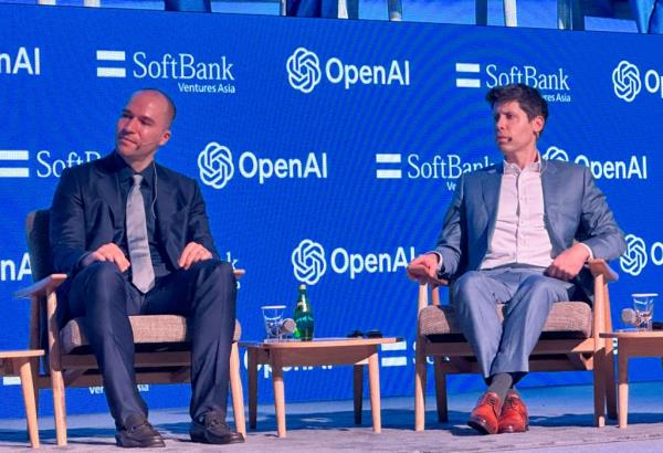 Sam Altman and Greg Brockman sit in chairs, attending a co<em></em>nference hosted by SoftBank Ventures Asia in Seoul.