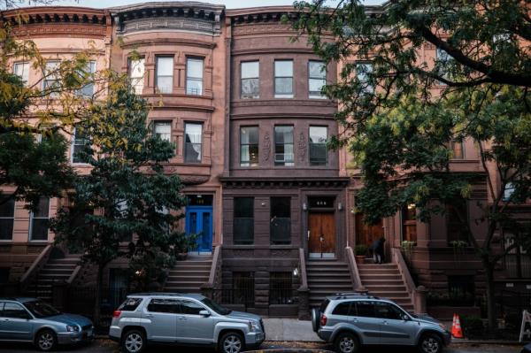 A brownstone building in Harlem with a brown door, one of four units wher<em></em>e residents protest against Joseph Makhani for stealing their home.