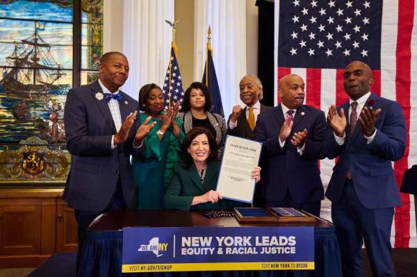 New York State Governor Kathy Hochul was joined by Rev. Al Sharpton, center rear, Speaker of the New York State Assembly Carl Heastie, 2nd from right, Majority Leader of the New York State Senate Andrea Stewart-Cousins, 2nd from left, and others as she signed a slavery reparations bill at the New York Historical Society on Tuesday, December 19, 2023 in New York, N.Y.