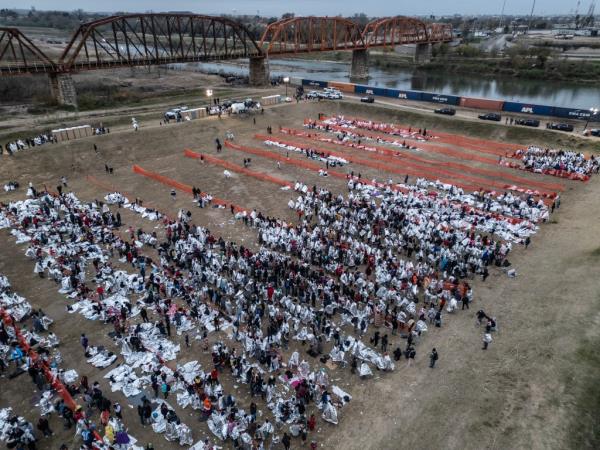 Thousands of migrants wait to be processed by the U.S. Border Patrol at a make-shift transit center after crossing the Rio Grande river into the U.S. from Mexico in Eagle Pass, Texas on December 20, 2023