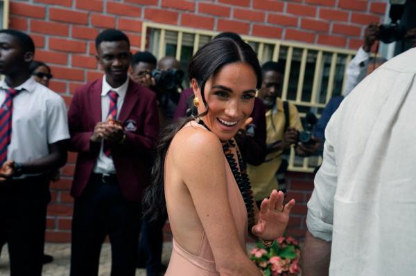 Meghan Markle gestures as she and Prince Harry visit children at the Lights Academy in Abuja, Nigeria, Friday, May 10, 2024.  