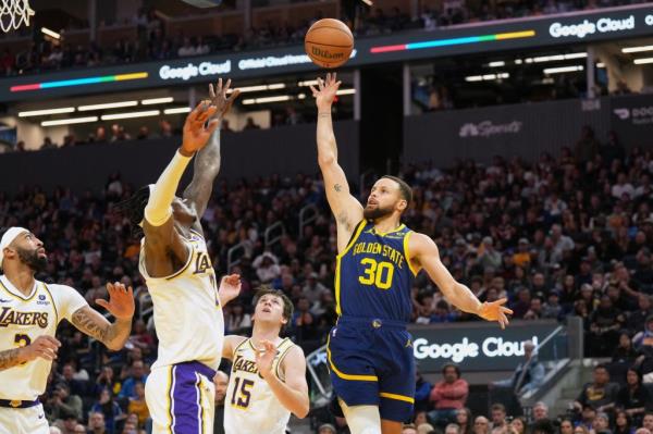 Warriors guard Stephen Curry (30) shoots against Los Angeles Lakers guards Gabe Vincent (second from left) and Austin Reaves