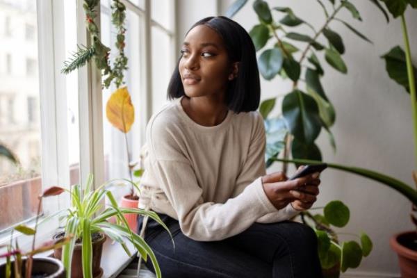 Woman at home looking outside window