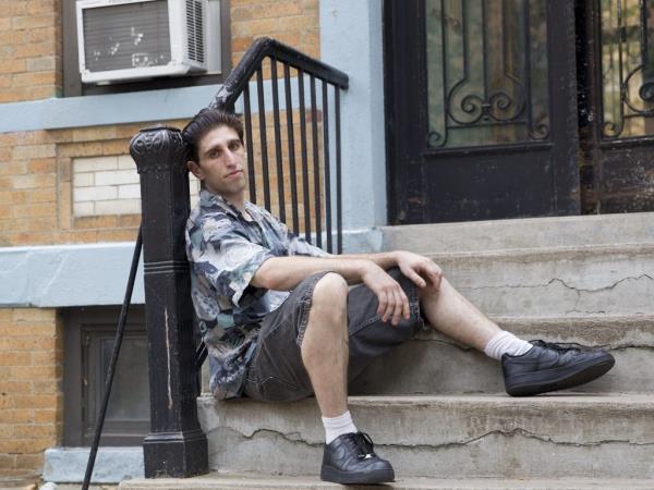 Buddy Duress sitting on steps in Astoria for the movie 