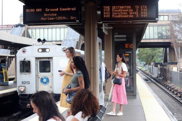 Commuters waiting to board a Metro-North train at Croton Harmon train station, anticipating Tropical Depression Debby