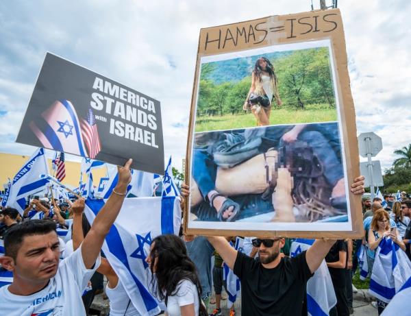 A man at a rally in support of Israel after the deadly attacks held up a photo of festival attendee, Shani Louk, who was kidnapped and paraded around by Hamas terrorists.