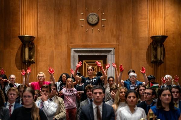 Pro-Palestinian demo<em></em>nstrators hold painted hands as U.S. Secretary of State Antony Bl<em></em>inken started to speak.</p>

<p>　　