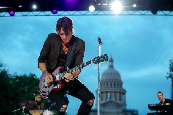 Keith Urban performing o<em></em>nstage with a guitar at the 2023 CMT Music Awards in Austin, Texas