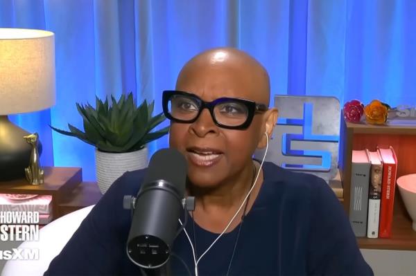 Robin Quivers bald, talking. 