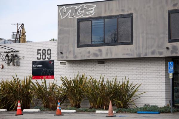 Vice Media company sign and For Lease sign on a building wall in Los Angeles, with a parking lot visible.