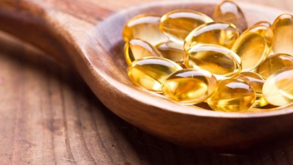 Cod liver oil omega 3 gel capsules isolated on wooden background