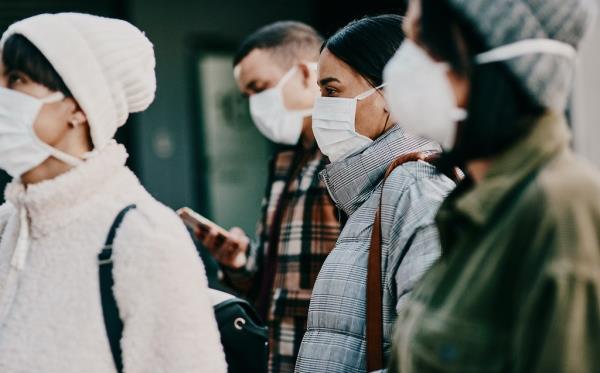 Traveling people wearing face mask in a covid pandemic in a crowd, public or airport border with passport or travel restrictions.