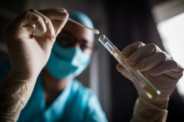 Doctor holding a coro<em></em>navirus COVID-19 test tube.