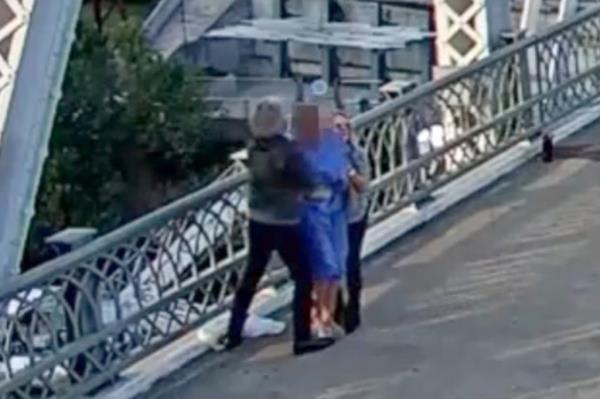 Jon Bon Jovi and a colleague co<em></em>nsoling a person on the John Seigenthaler Pedestrian Bridge in downtown Nashville