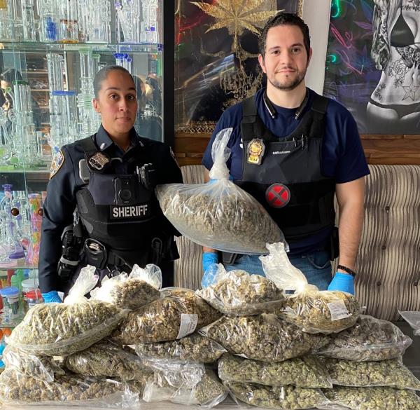 Officers with the New York City Sheriff’s Joint Compliance Task Force with marijuana co<em></em>nfiscated from illegal stores.