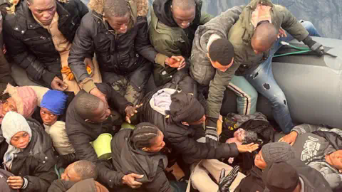 SALVAMENTO MARITIMO/REUTERS African migrants rugged up in winter coats surround a baby just minutes after it was born on a dinghy off the coast of Spain's Canary Islands