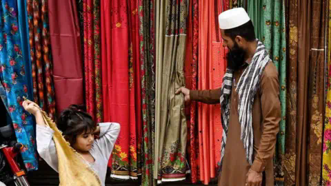 Getty Images A shopkeeper and a child at aroadside shop in Lahore, Pakistan.