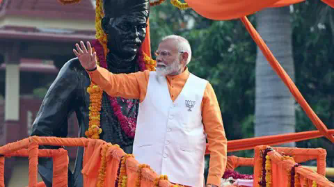 Getty Images Narendra Modi, India's prime minister, wearing white jacket over an orange shirt and a lotus badge greets supporters during a campaign rally in Varanasi, Uttar Pradesh, India, on Monday, May 13, 2024