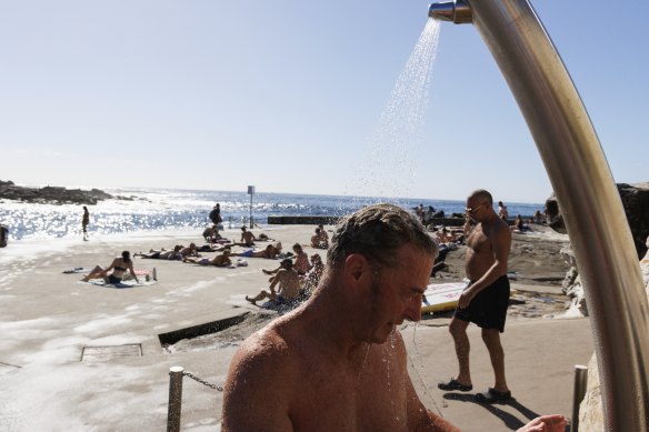 Gervase Green rinses off after a morning swim at Clovelly on Sunday. Sydneysiders woke to warm conditions. 