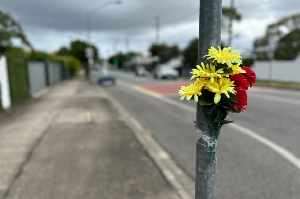 Flowers remain affixed to the pole wher<em></em>e the ghost bike was previously left.